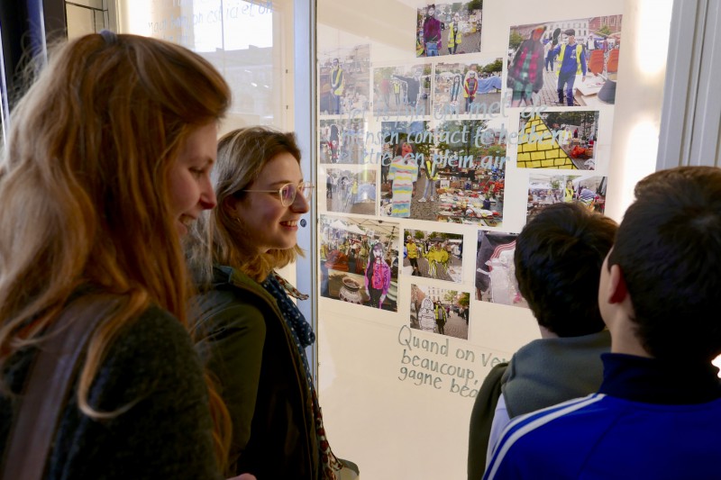 Jongeren en kinderen kijken naar de werken in de vitrine