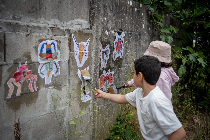 Kinderen plakken illustraties op muur